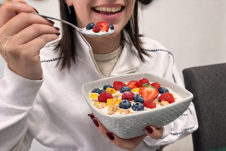 Mujer disfrutando de una merienda refrescante para mantener una nutrición equilibrada y una alimentación saludable.