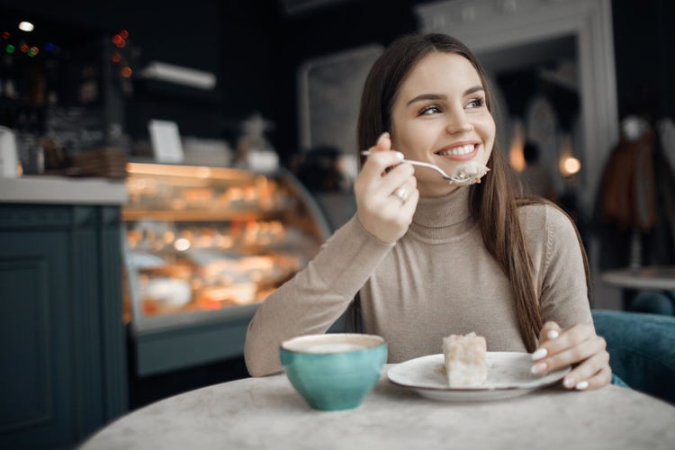 Mujer disfrutando de un postre, aprendiendo a regular la alimentación emocional sin culpa.