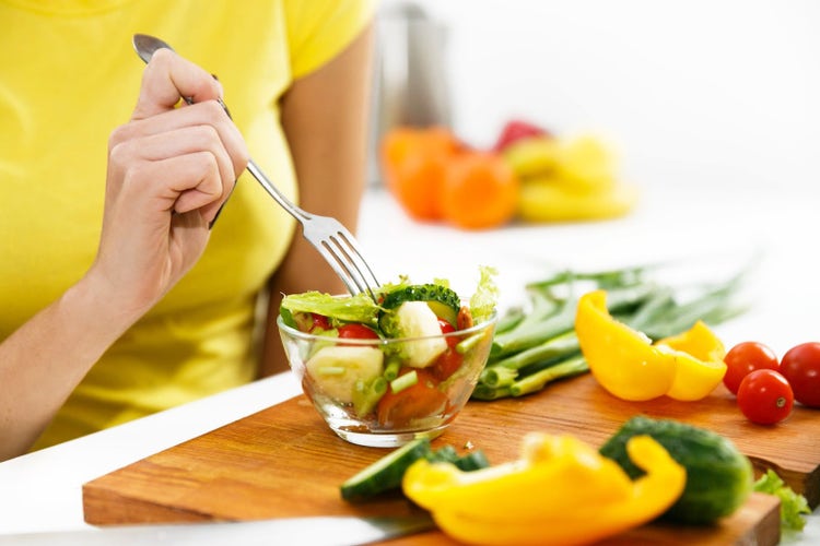 Mujer disfrutando de una ensalada fresca para mantener una nutrición equilibrada y una alimentación saludable.